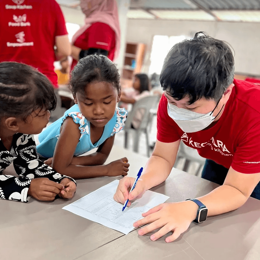A volunteers teaching Orang Asli kids how to count